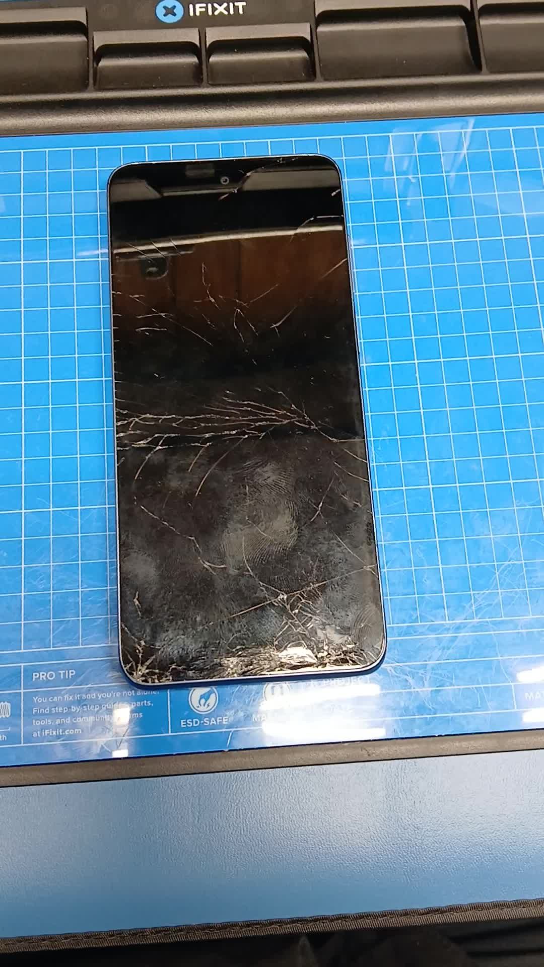 Moto G Stylus on the bench mat before repair: cracks across the whole display